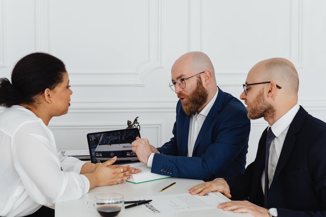 Team members in a meeting reviewing a computer