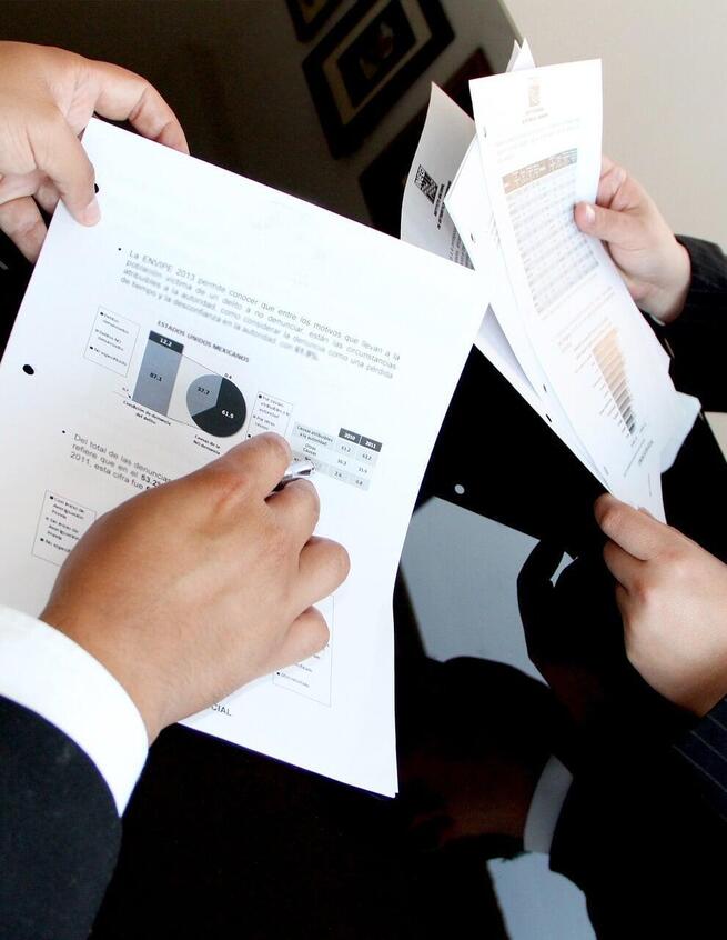 Business men reviewing printed reports